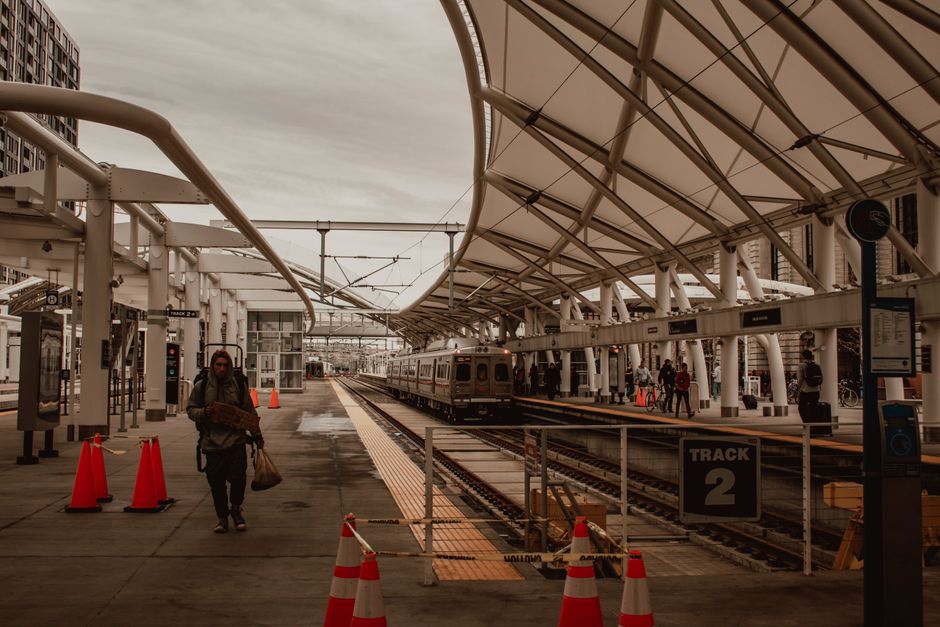 A series of modern commuter trains with yellow and grey livery are stationary on railway tracks near Richmond Station, with multiple parallel tracks and overhead electric wires visible in the scene. I